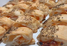 Mini Bauru Folhado Enroladinhos folhados com recheio de frios e vinagrete, cobertos com orégano.