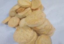 Moedinha de queijo Moedinhas de queijo em pilhas, sobre um fundo branco e moldura preta.