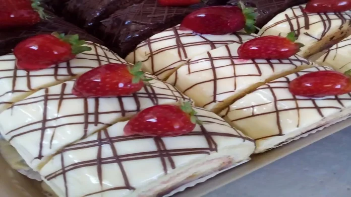 Oito fatias de rocambole, enfitados com riscos finos de chocolate que formam uma tela sobre cada fatia, e um morando inteiro sobre cada fatia.